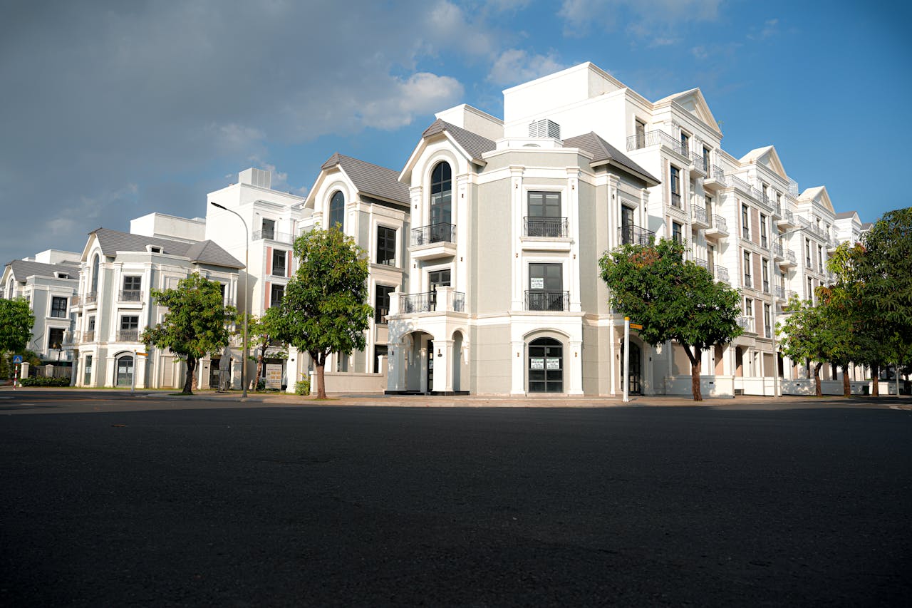 about-03 A modern apartment complex with classic architectural design under a bright blue sky.